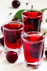 Homemade cherry liqueur and fresh cherries, selective focus