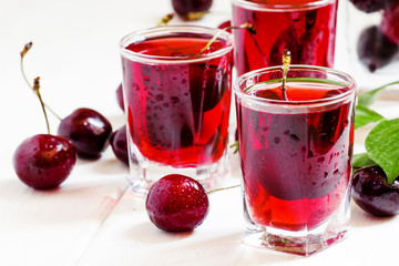 Homemade cherry liqueur and fresh cherries, selective focus
