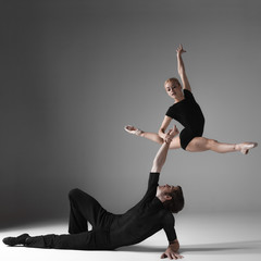two young modern ballet dancers on gray studio background 