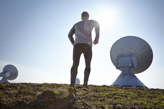 Germany, Raisting, young man jogging at ground station