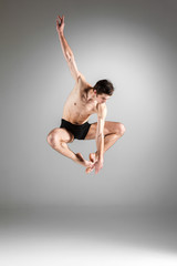 Fototapeta premium The young attractive modern ballet dancer jumping on white