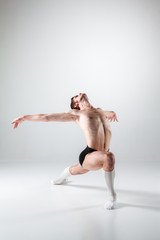 The young attractive modern ballet dancer on white background