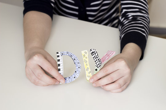 Hand holding letters DIY in Zendoodle style