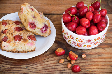 Ripe organic homegrown cherries and cherry cake, on wooden background