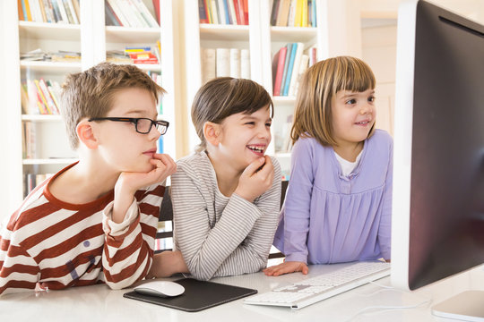 Boy and his two sisters spending time at computer
