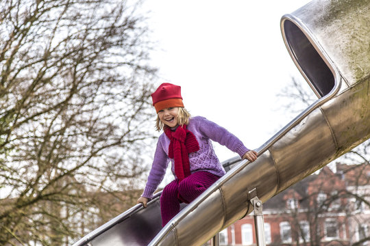 Germany, Kiel, Little girl with red cap playing on shoot