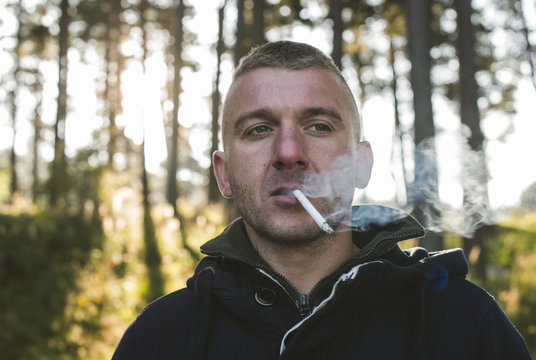Bulgaria, man smoking cigarette in the forest