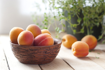 apricots in ceramic cup on wooden table. selective focus