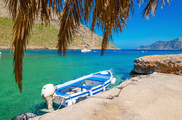 Blue and white wooden boat in cosy Greek port - obrazy, fototapety, plakaty
