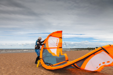 Kite surfer  is preparing his kite on a windy cold day