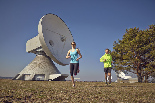 Germany, Raisting, young couple jogging at ground station