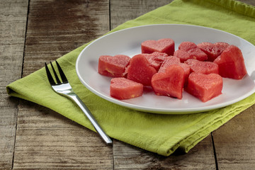 Slices of watermelon in the heart shape on vintage wooden table