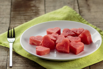 Slices of watermelon in the heart shape on vintage wooden table
