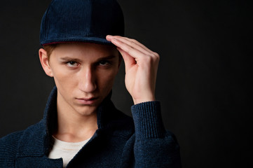 Boy with a baseball cap on a black background in studio
