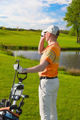 man golfer watching into rangefinder - obrazy, fototapety, plakaty