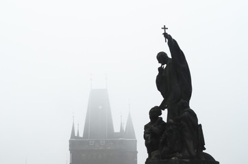 Czech Republic, Prague, statue on Charles Bridge in morning fog
