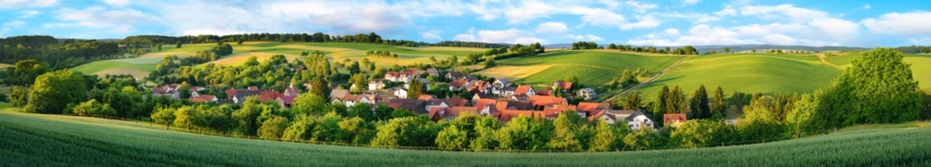 Fototapeten Ortschaft und grüne Hügel, extra breites Panorama © Smileus