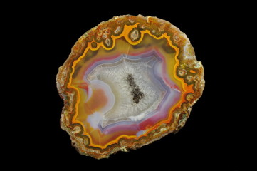 A cross section of agate stone with geode on a black background.  Origin:  Morocco, Aquim.  