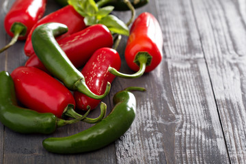 Green and red hot pepper on table