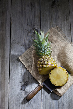 Ananas, jute and old cleaver on wood