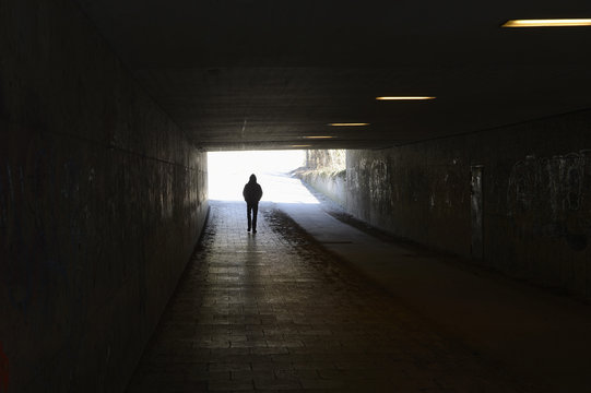 Person walking in tunnel - Powered by Adobe