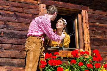 Verliebtes Paar beim Fensterln in Hütte