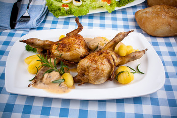 Two fried quail with gnocchi, gravy and rosemary
