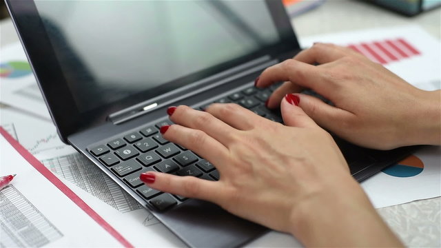 Woman hands typing on a laptop, close up