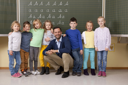 Happy teacher with pupils in classroom