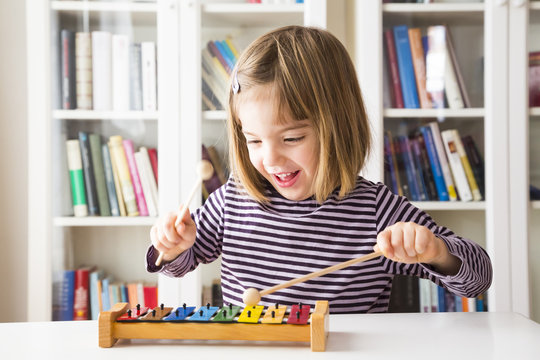 Portrait of happy little girl playing xylophones