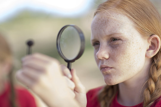 South Africa, Girl on field trip looking through magnifying glass