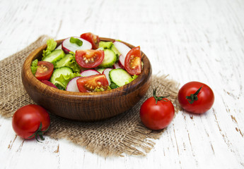 Fototapeta na wymiar Spring salad with tomato, cucumbers and radish