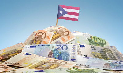 Flag of Puerto Rico sticking in a pile of various european bankn