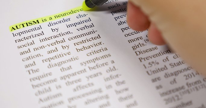 The definition of Autism being emphasized by a yellow marker...