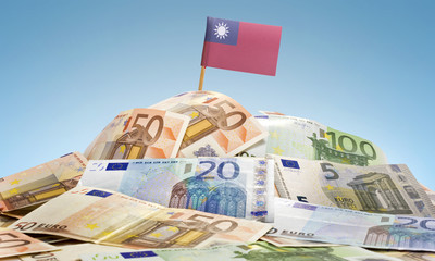 Flag of Taiwan sticking in a pile of various european banknotes.