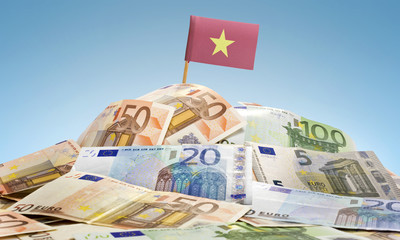 Flag of Vietnam sticking in a pile of various european banknotes