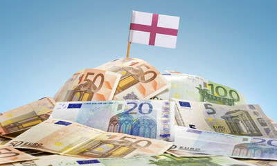 Flag of England sticking in a pile of various european banknotes