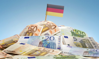 Flag of Germany sticking in a pile of various european banknotes