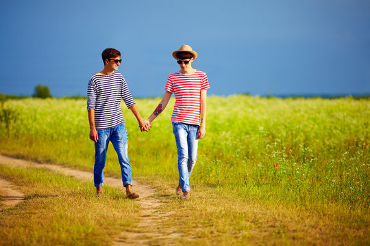 two boys in love walking together on summer field