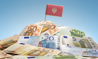 Flag of Montenegro sticking in a pile of various european bankno