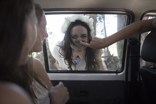 South Africa, Friends on a road trip pulling funny faces at car window