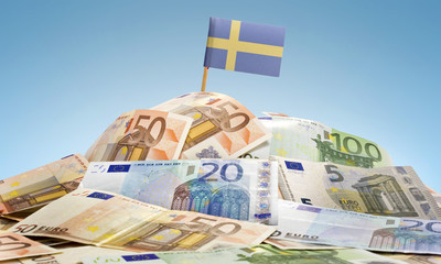Flag of Sweden sticking in a pile of various european banknotes.