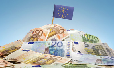 Flag of Indiana sticking in a pile of various european banknotes