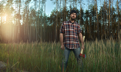 Bearded Lumberjack in Hat holding a big Ax in Hand