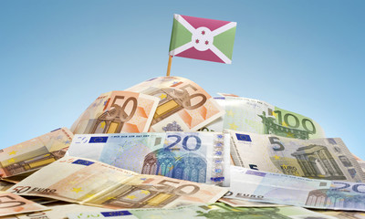 Flag of Burundi sticking in a pile of various european banknotes