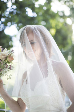 Happy bride with veil at her wedding