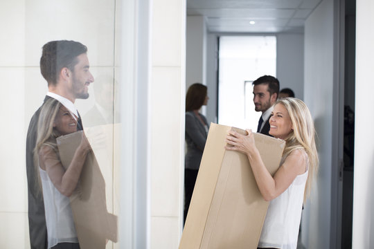Businesswoman carrying big box through office