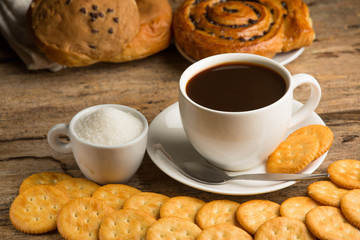 Cup of coffee on a wooden board and biscuits