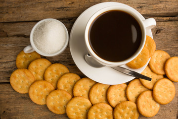 Cup of coffee on a wooden board and biscuits