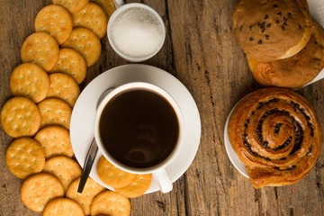 Cup of coffee on a wooden board and biscuits